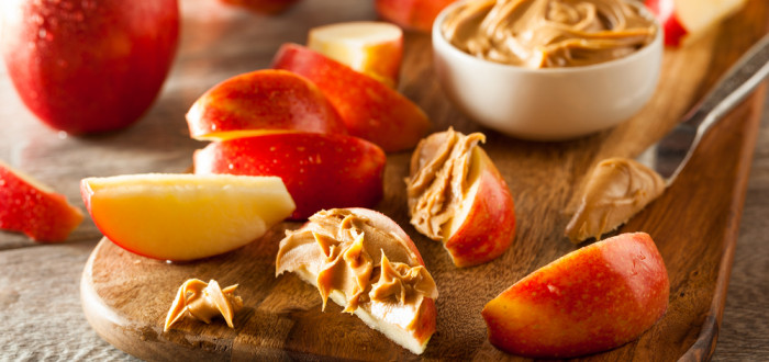 Arašídové máslo můžete nabírat nakrájeným jablkem, jde o ideální zdravou svačinku